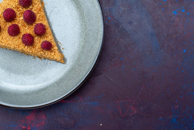 Top view of cake slice delicious with raspberries on dark surface