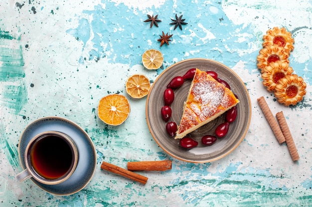 Top view cake slice with cookies and cup of tea on a blue surface fruit cake bake pie biscuit sweet