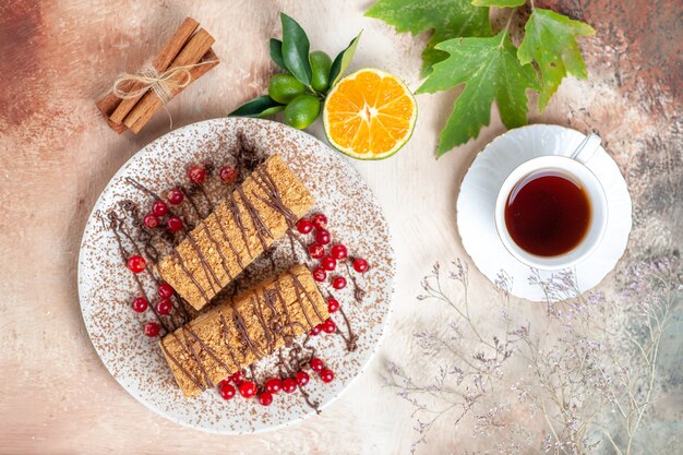 光の上のベリーとお茶とトップビューのケーキのスライス