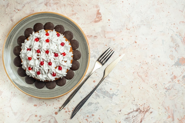 Top view cake with pastry cream and chocolate fork and dinner knife