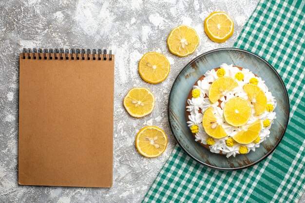 녹색 흰색 체크 무늬 식탁보에 플래터에 생 과자 크림과 레몬 상위 뷰 케이크