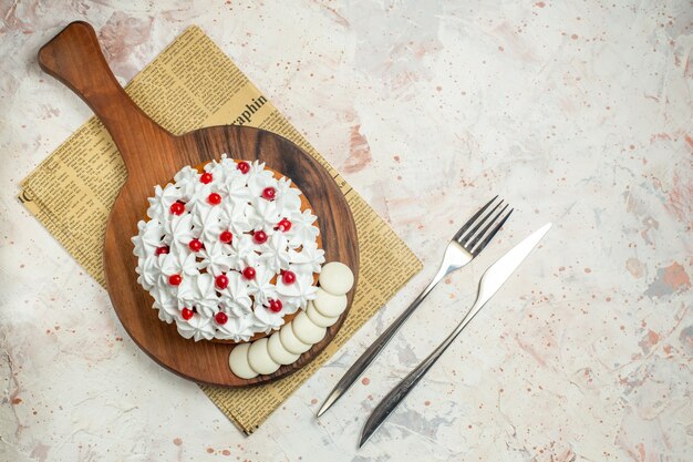 Торт с кремом из белого теста на разделочной доске, вид сверху