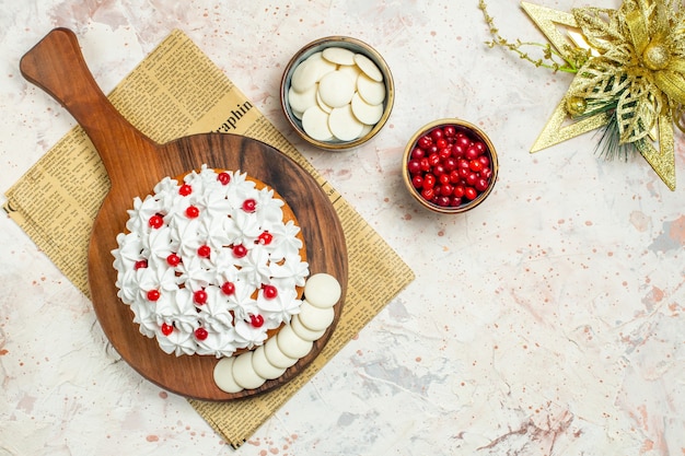 신문 및 크리스마스 장식에 나무 보드에 흰색 과자 크림과 함께 상위 뷰 케이크