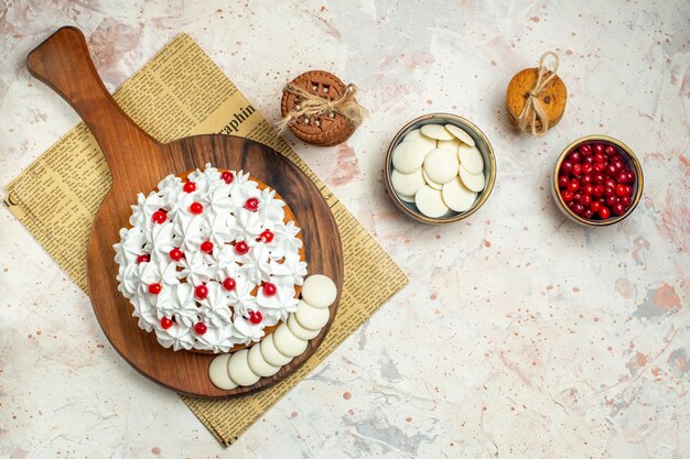 Top view cake with white pastry cream on wood board on newspaper