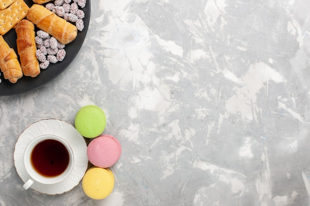 Top view cakes and bagels with candies crackers and cup of tea on white desk cake biscuit cookie sugar sweet pie