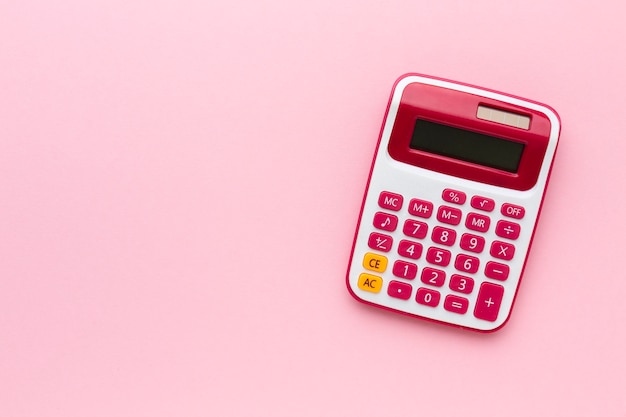Бесплатное фото Калькулятор вид сверху на розовом фоне