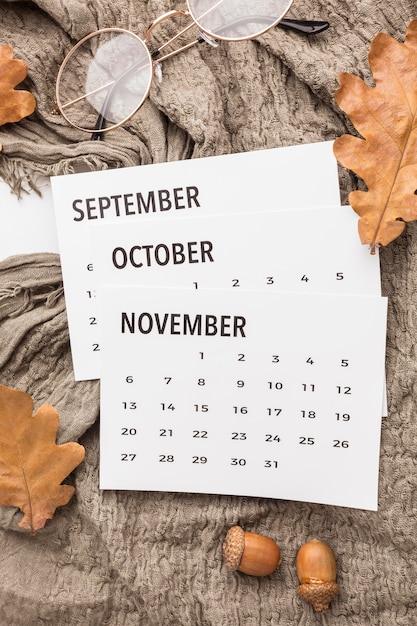 Top view of calendar with autumn leaves and glasses