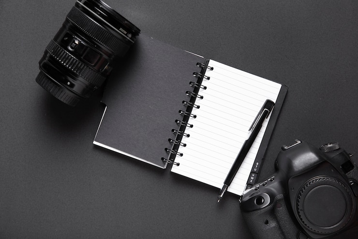 Free Photo top view of camera and notebook