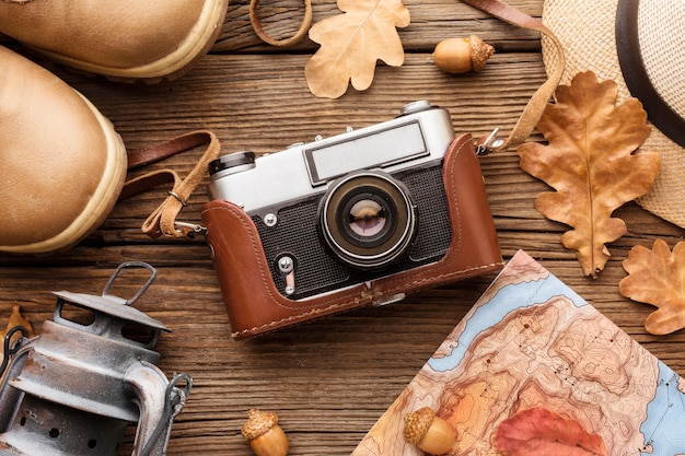 Top view of camera with autumn leaves and boots