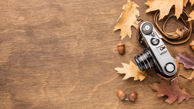 Top view of camera with autumn leaves and copy space