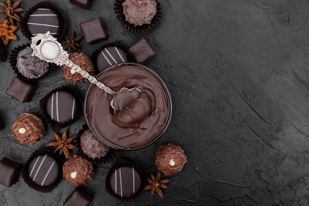 Вид сверху конфеты и растопленный шоколад с копией пространства