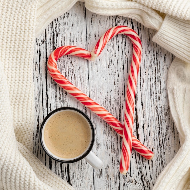 Top view of candy canes in heart shape with cup of hot cocoa