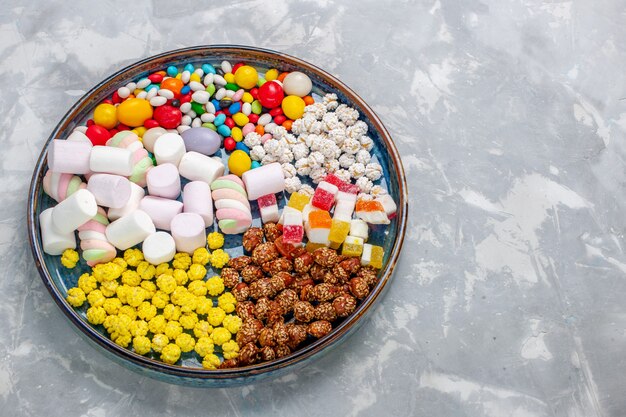 Top view candy composition different colored candies with marshmallow on the light white desk sugar candy bonbon sweet confiture