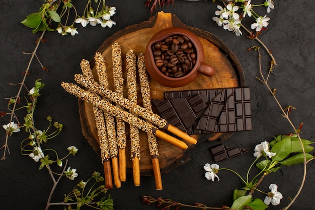 top view candy sticks chocolate coffee seeds on the brown desk and dark