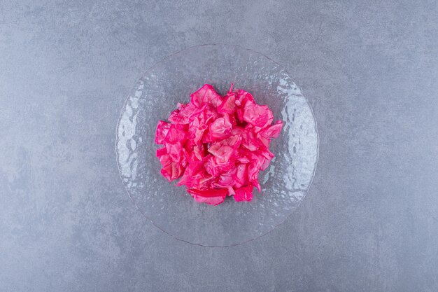 Top view of canned pink cabbage on glass plate.