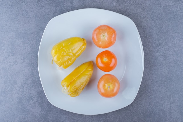 缶詰の野菜の上面図。白い皿にトマトとコショウ。