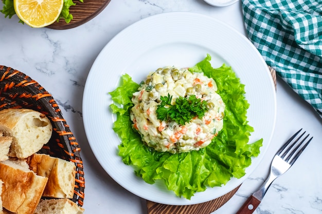 Top view capital salad on lettuce in a plate with bread in a basket