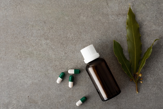 Top view capsules with bottle of oil on the table