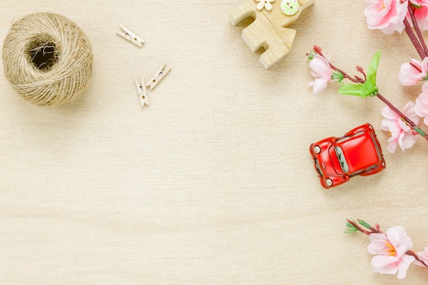 Top view car house rope and flower on wooden background.