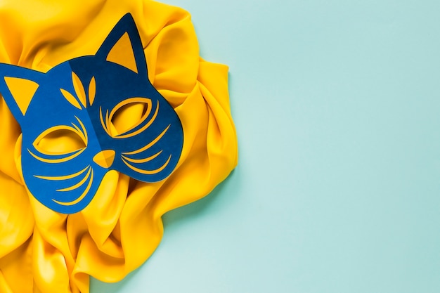 Vista superiore della maschera felina di carnevale sul tessuto con lo spazio della copia