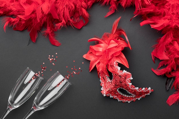 Top view of carnival masks with feathers and champagne glasses