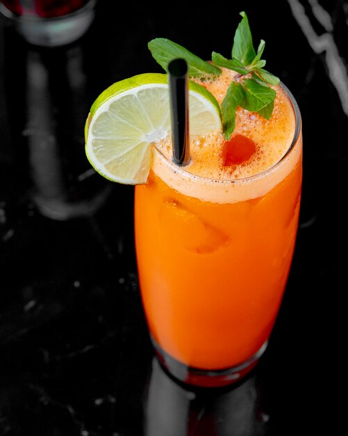 Top view carrot juice with a slice of lime and min