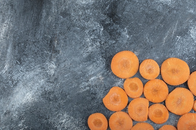 Top view of carrot slices on grey background.