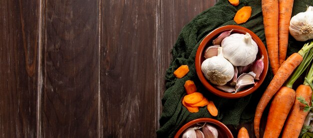 Top view of carrots and bowl of garlic