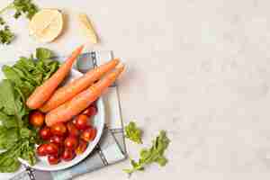 Free photo top view of carrots and tomatoes on plate