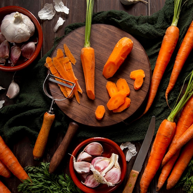 Top view of carrots with peeler and garlic