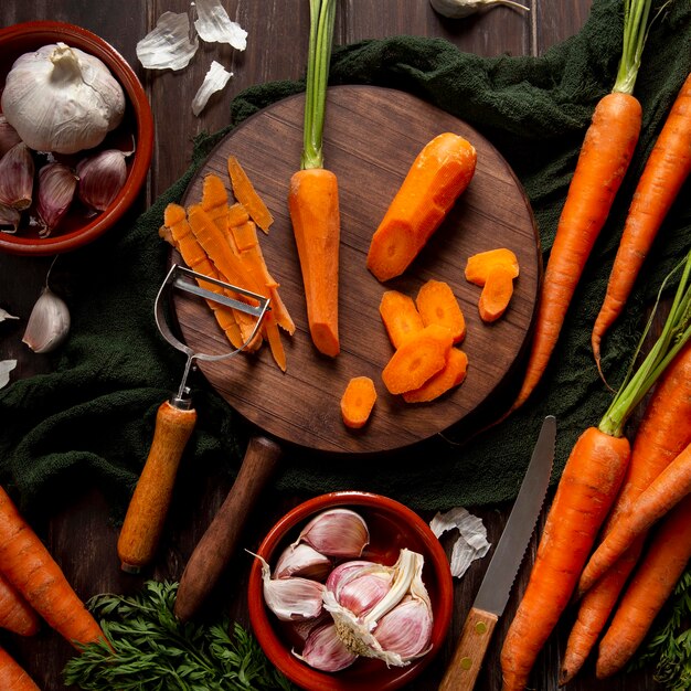 Top view of carrots with peeler and garlic