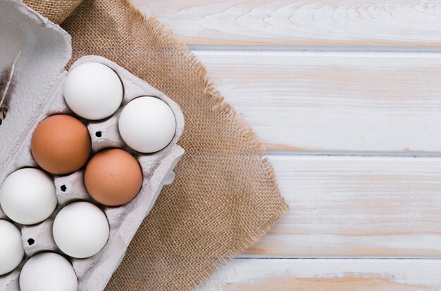 Top view of carton of eggs with burlap and copy space