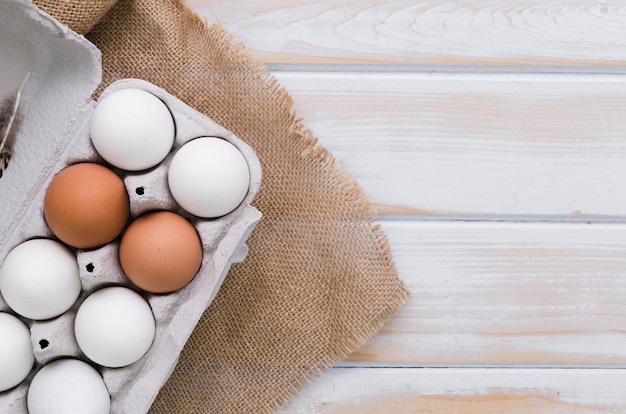 Top view of carton of eggs with burlap and copy space