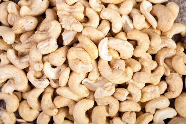 Over top view of Cashew nuts on wooden background in studio photo. Raw healthy food