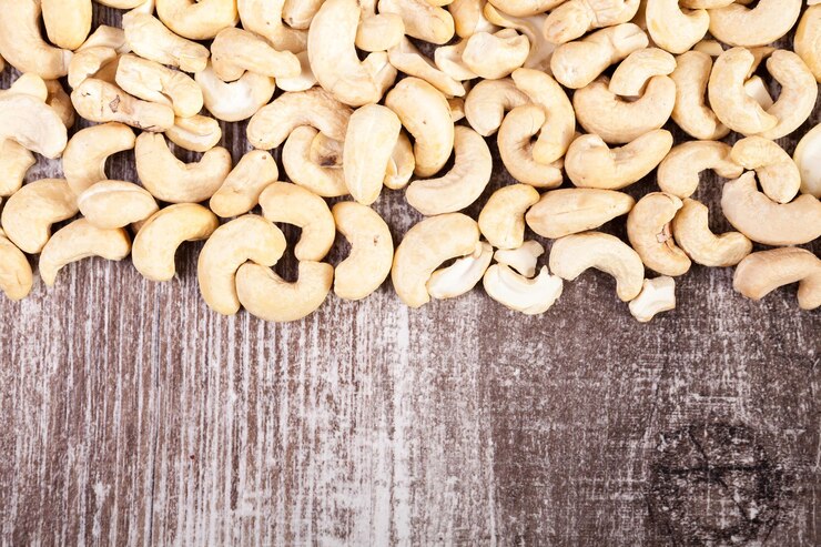 Free Photo over top view of cashew nuts on wooden background in studio photo. raw healthy food
