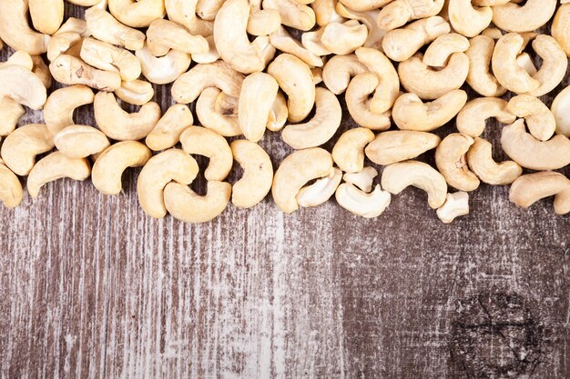 Over top view of Cashew nuts on wooden background in studio photo. Raw healthy food