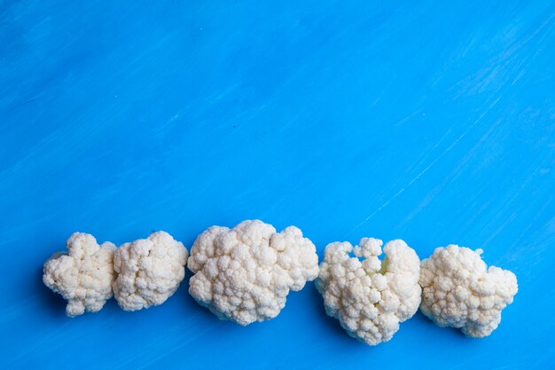 Top view cauliflower on cyan blue background. horizontal space for text