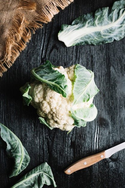 Top view cauliflower with leaves and knife