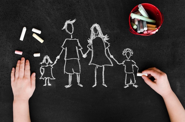 Free photo top view chalk drawing of parents with their children on blackboard