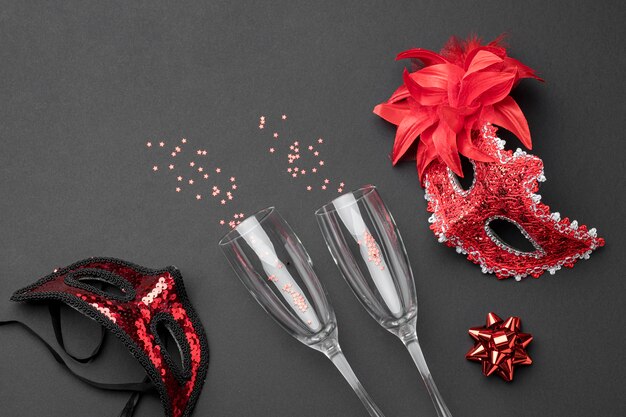 Top view of champagne glasses and carnival masks with feathers