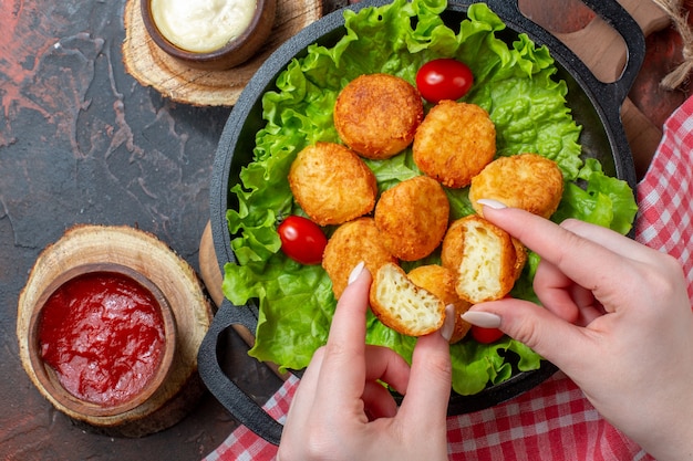 Top view cheese balls and sauces in pan on dark surface