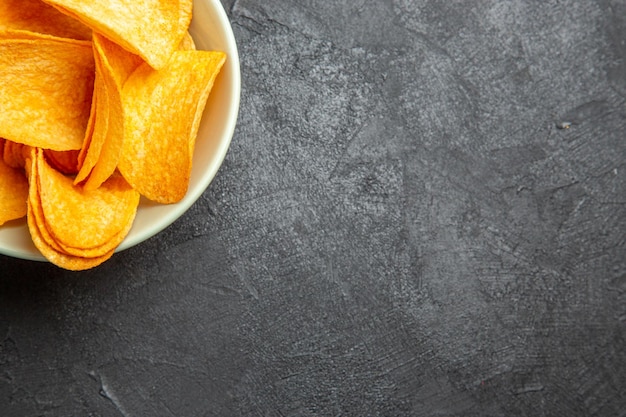 Top view cheese cips inside plate on a dark background