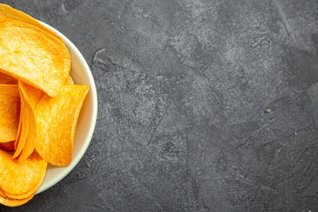 Top view cheese cips inside plate on dark background