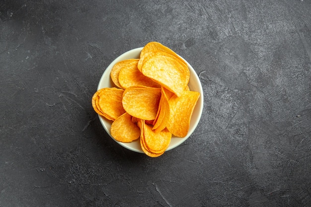 Top view cheese cips inside plate on dark background