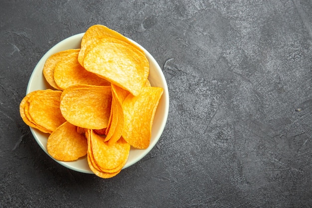 Top view cheese cips inside plate on dark background