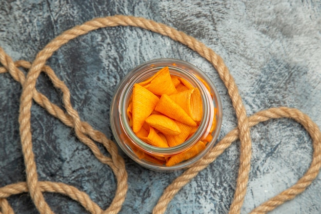 Top view cheese cips with ropes on dark surface