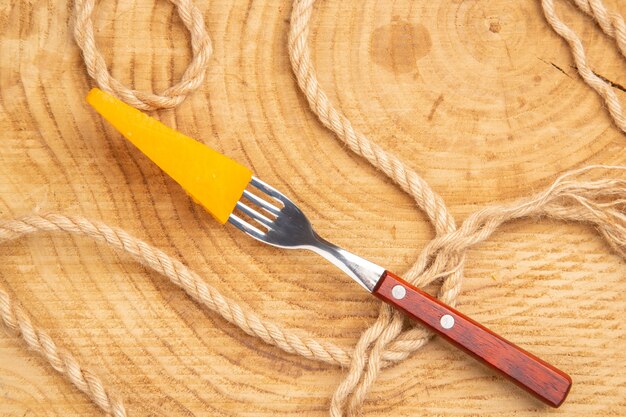 Top view cheese on fork rope on wooden table