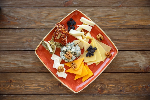 Top view of cheese plate with cheddar, gouda, white, and blue cheese