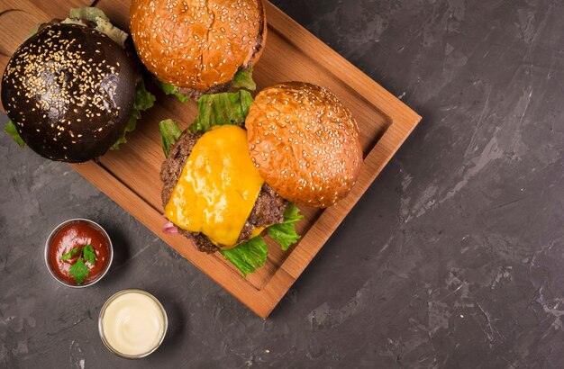 Top view cheeseburgers on a wooden board