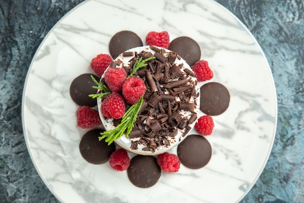 Free photo top view cheesecake with chocolate on white oval plate on grey surface food photo